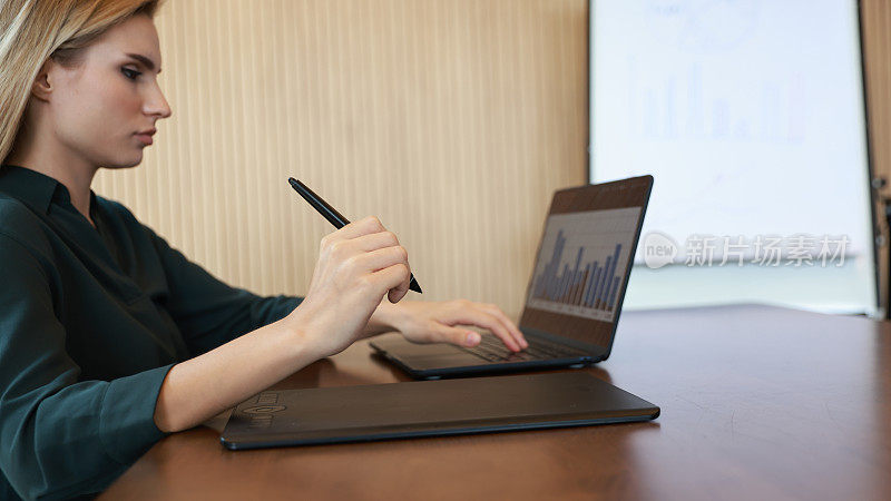 A Female officer using a digital pen and digital board working on a notebook in the boardroom
